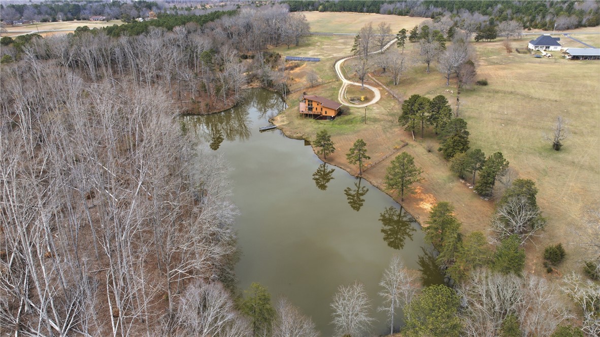 1531 Highway 252 Laurens, SC 29360 - Photo 37 of 40 This elevated view captures a charming lakeside residence nestled amidst a serene wooded landscape.
