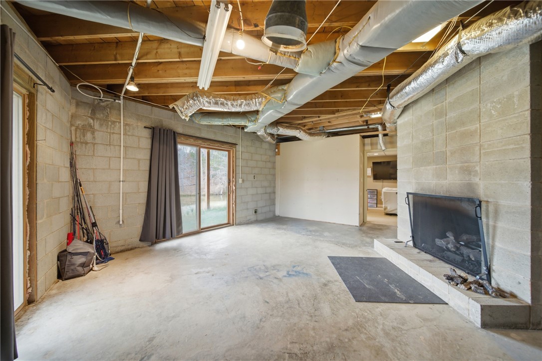 1531 Highway 252 Laurens, SC 29360 - Photo 38 of 40 This spacious basement offers ample opportunities for customization and enjoyment, featuring a fireplace and sliding glass door.