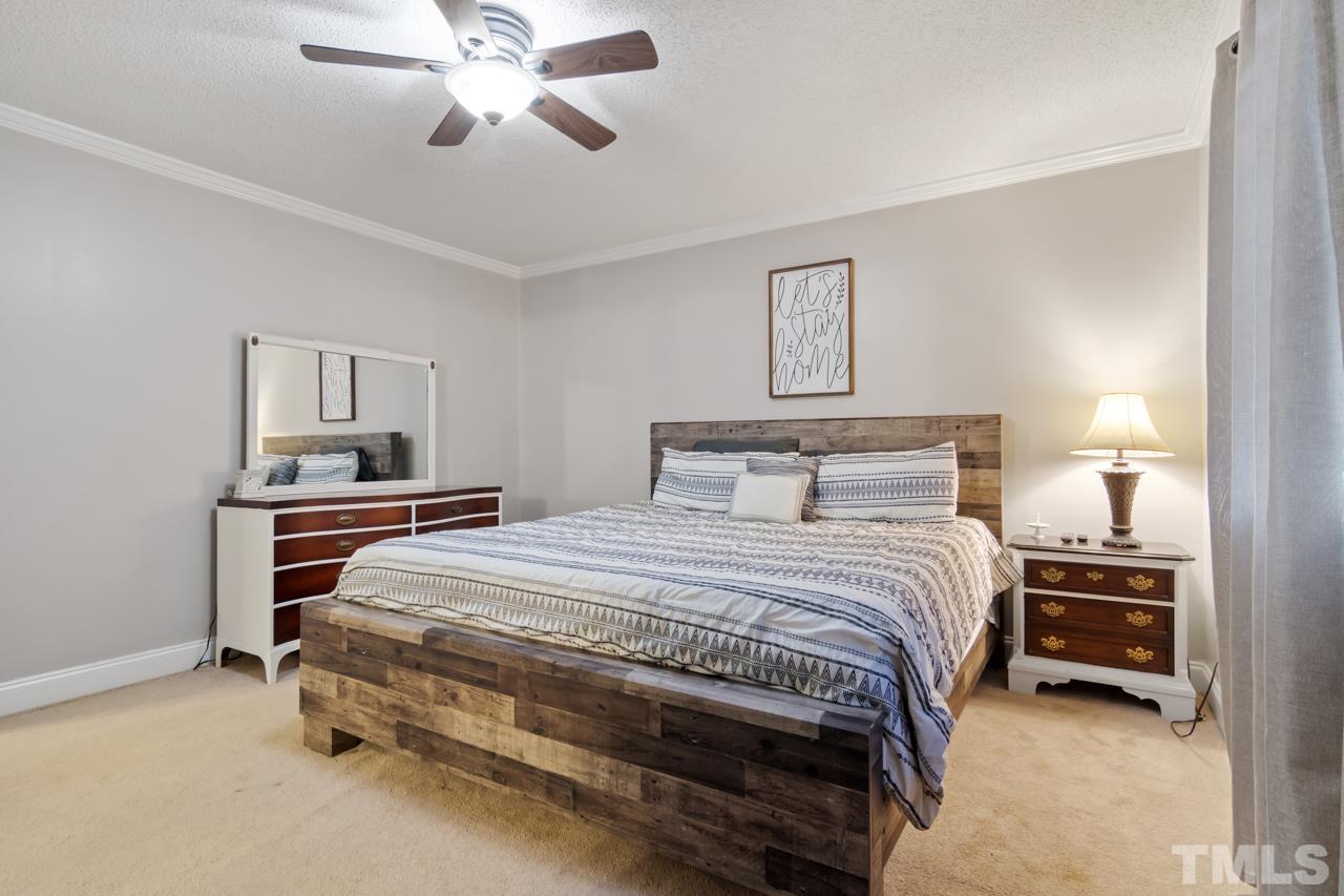 6908 Kiger Road Rougemont, NC 27572 - Photo 20 of 30 a bedroom with a bed and a chandelier