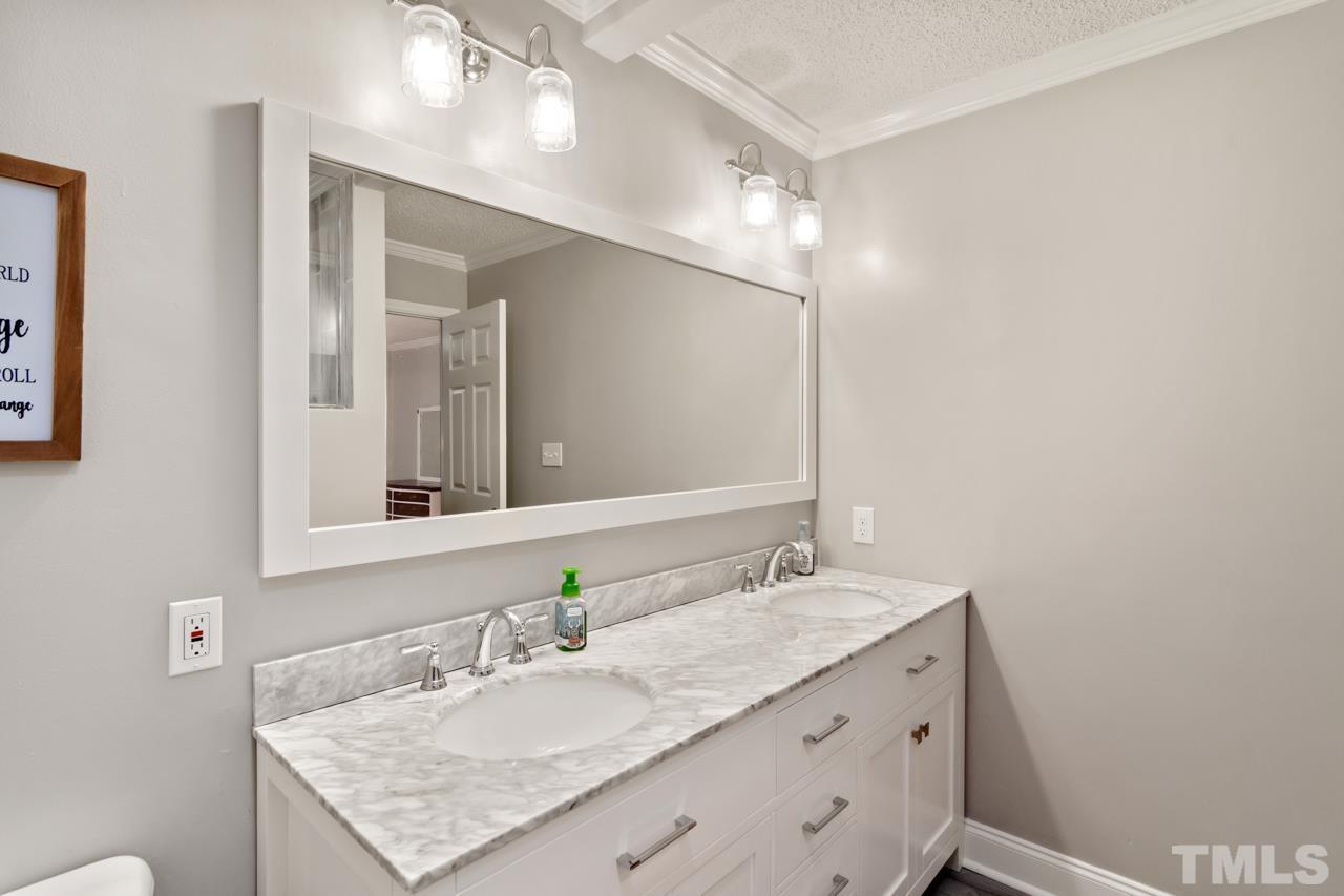 6908 Kiger Road Rougemont, NC 27572 - Photo 22 of 30 a bathroom with a granite countertop sink a large mirror and vanity