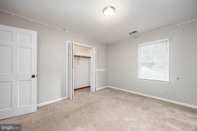 a front view of house with yard and trees in the background