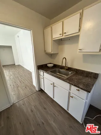 a kitchen with granite countertop a sink a stove and cabinets
