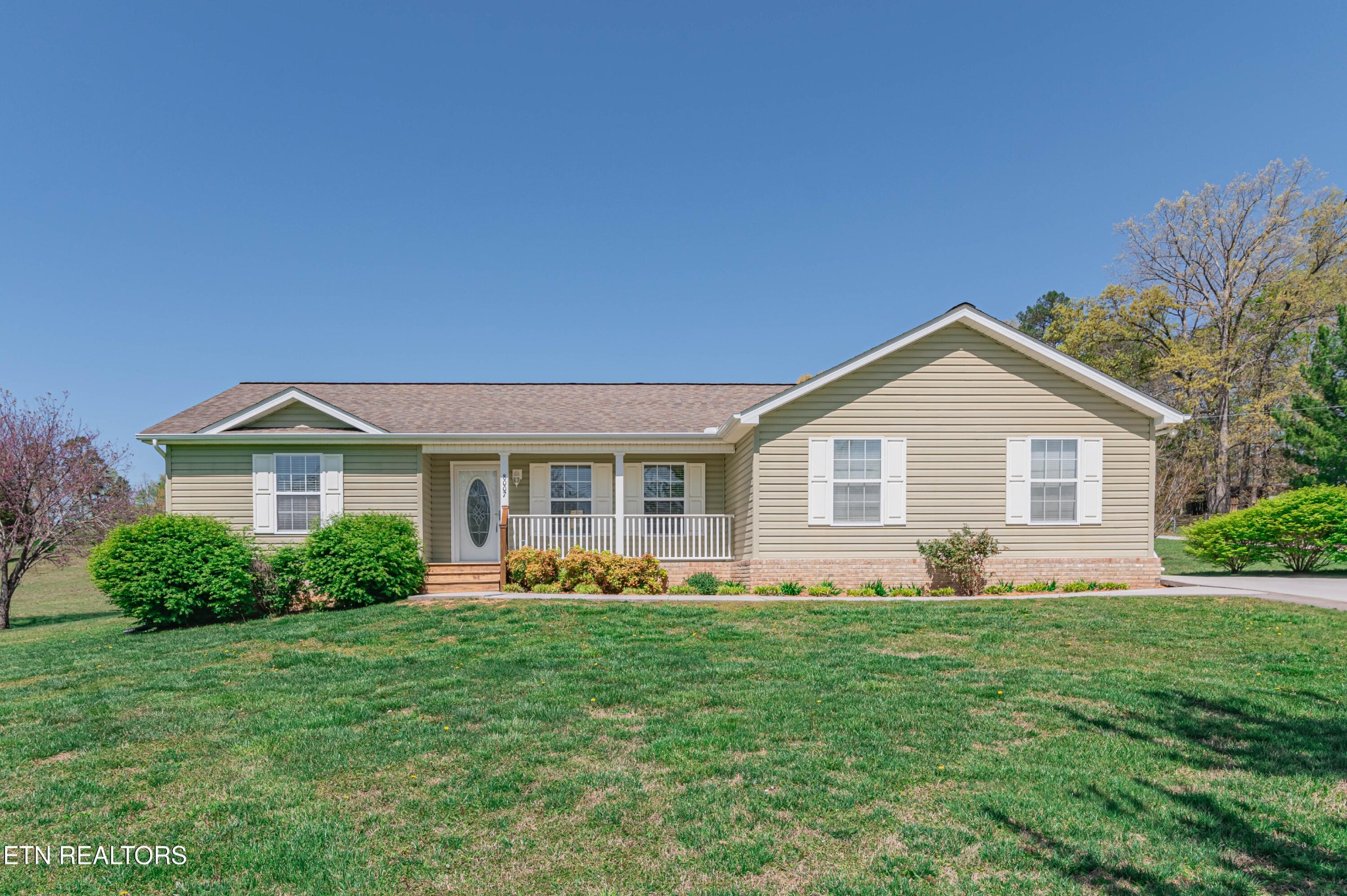 a front view of house with yard and green space