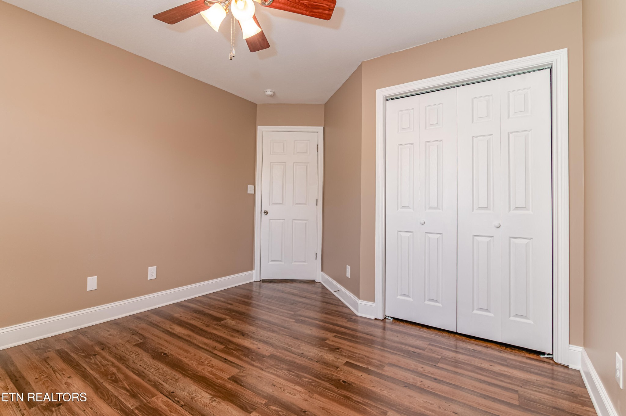 8007 Tazewell Pike Corryton, TN 37721 - Photo 19 of 43 a view of an empty room with wooden floor and a chandelier fan