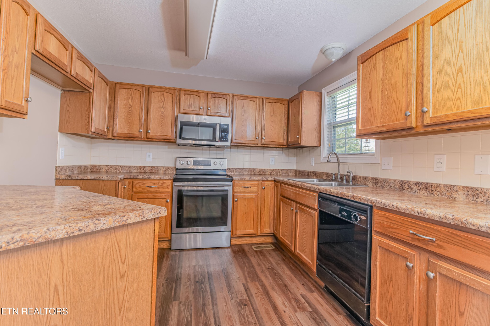8007 Tazewell Pike Corryton, TN 37721 - Photo 7 of 43 a kitchen with stainless steel appliances granite countertop wooden cabinets a sink and a stove