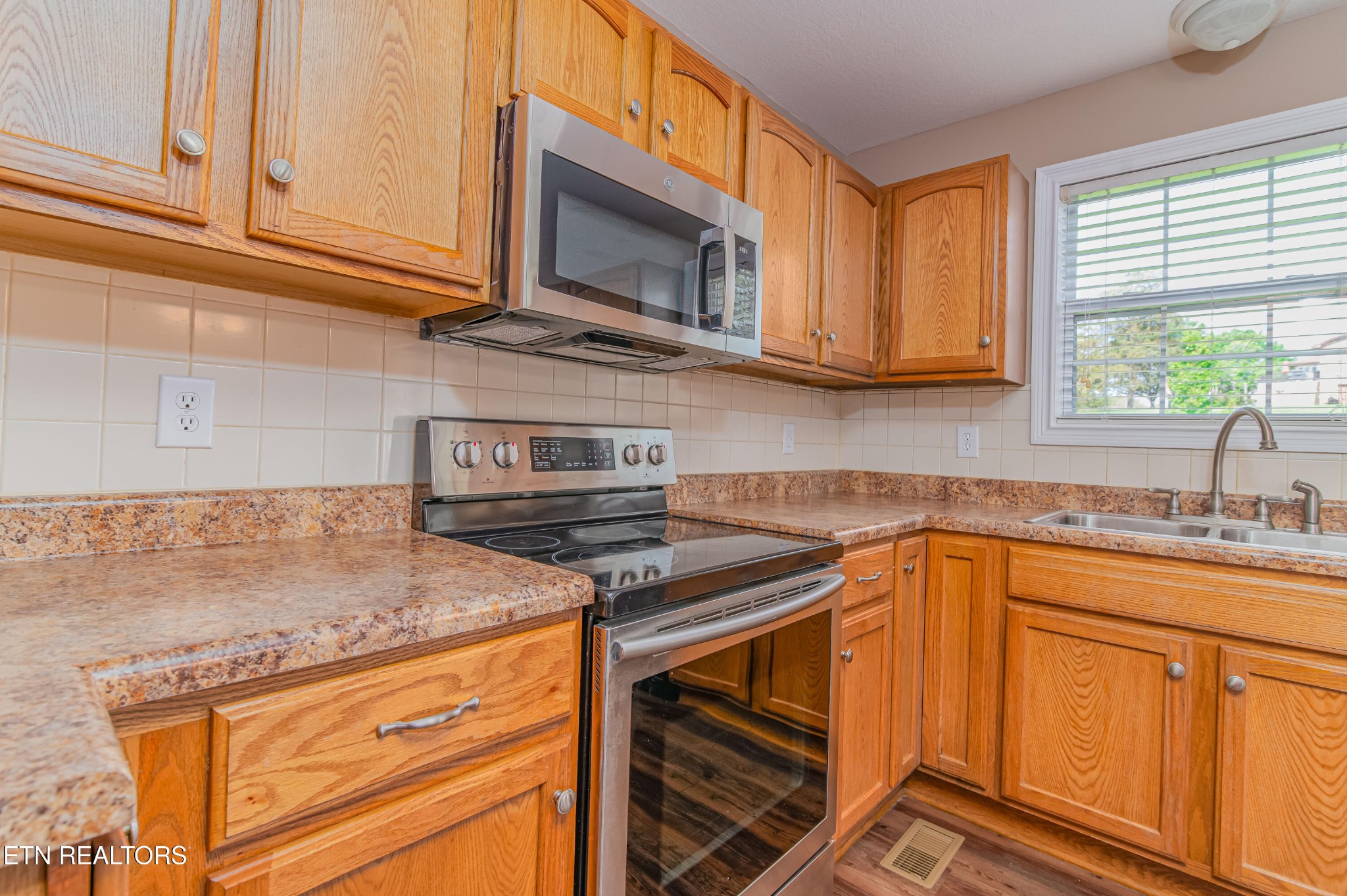 8007 Tazewell Pike Corryton, TN 37721 - Photo 8 of 43 a kitchen with stainless steel appliances granite countertop a sink stove and microwave