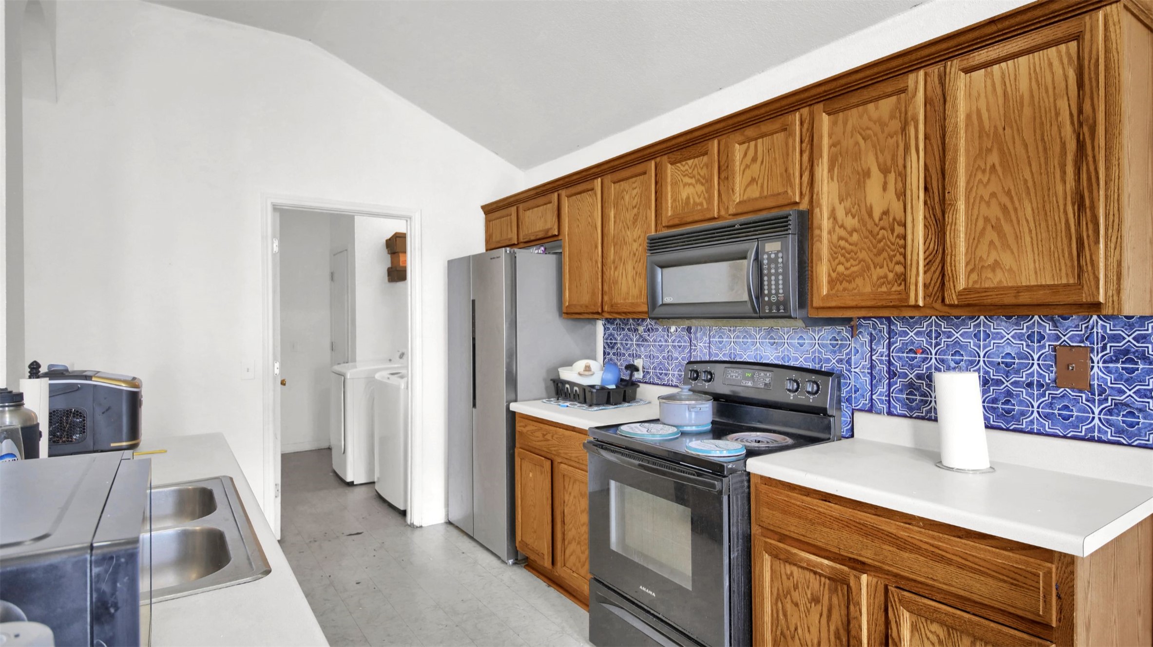 9609 Magna Carta Loop Austin, TX 78754 - Photo 13 of 30 a kitchen with stainless steel appliances granite countertop a stove a sink and a microwave