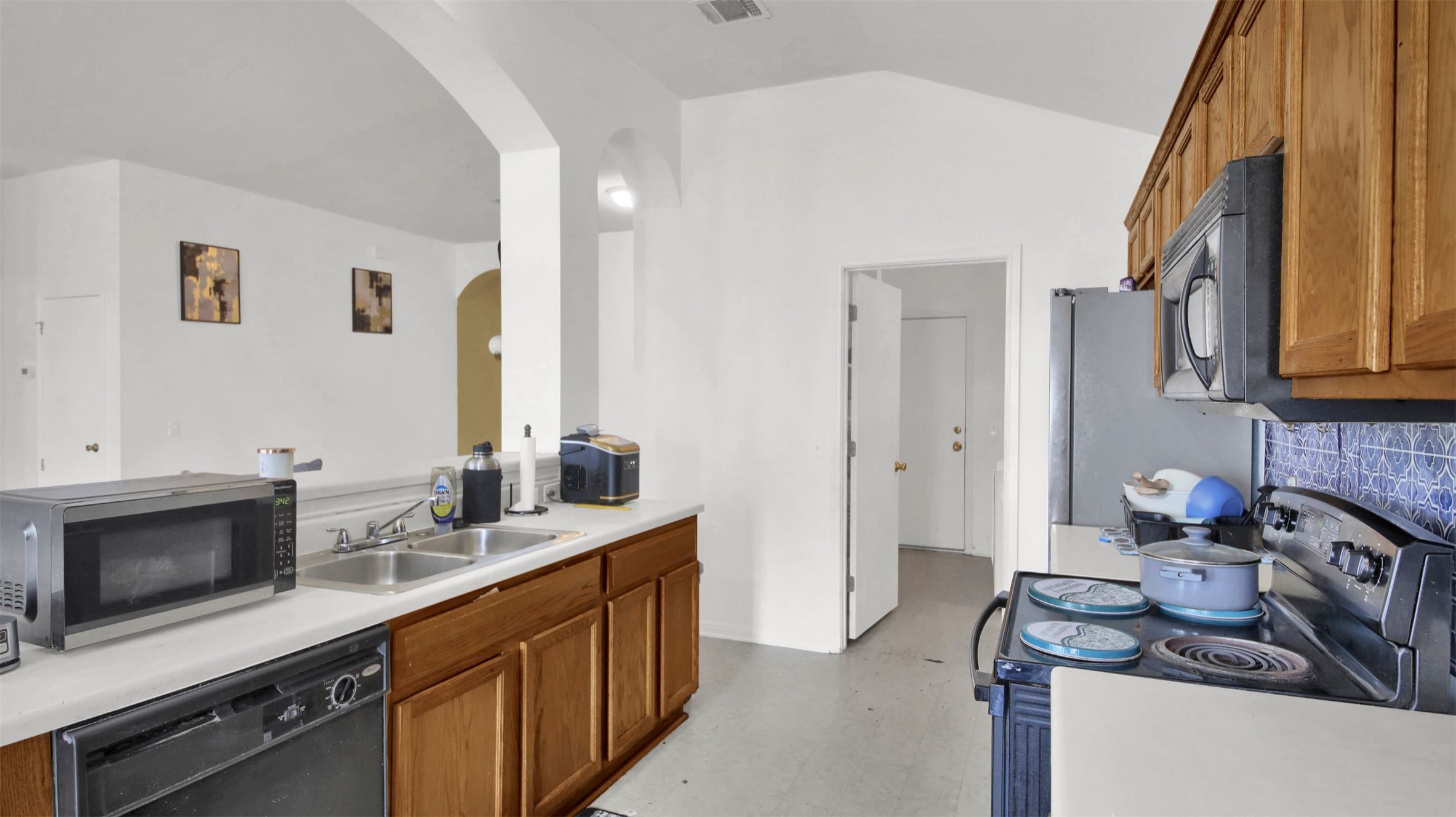 9609 Magna Carta Loop Austin, TX 78754 - Photo 14 of 30 a kitchen with stainless steel appliances a stove a sink and a microwave