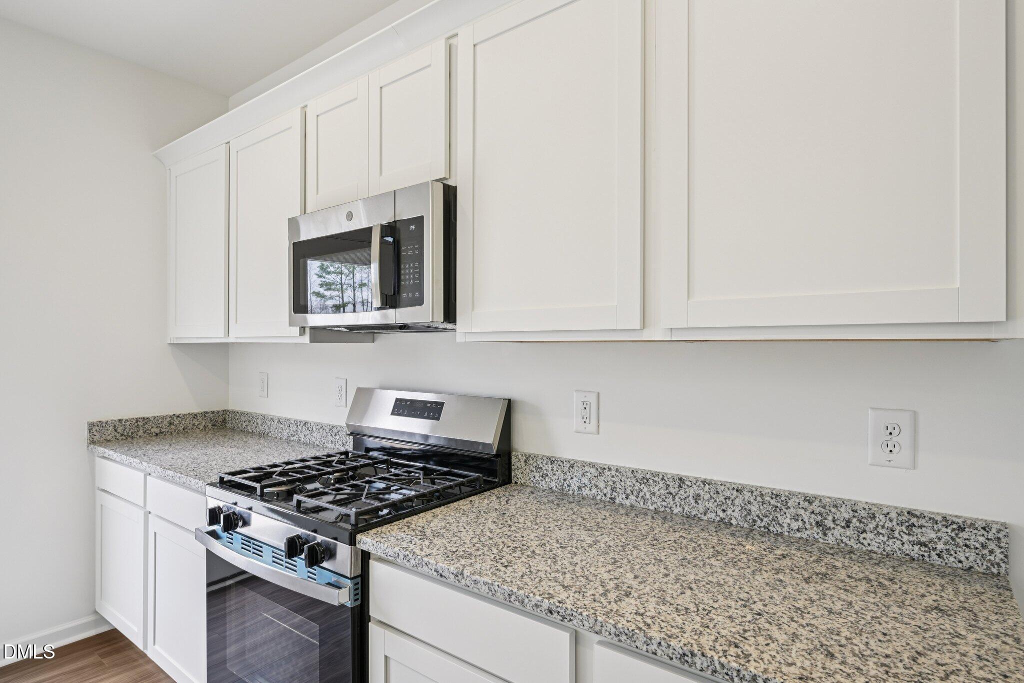 1610 Mirth Court Rolesville, NC 27571 - Photo 15 of 36 a kitchen with granite countertop white cabinets and stainless steel appliances