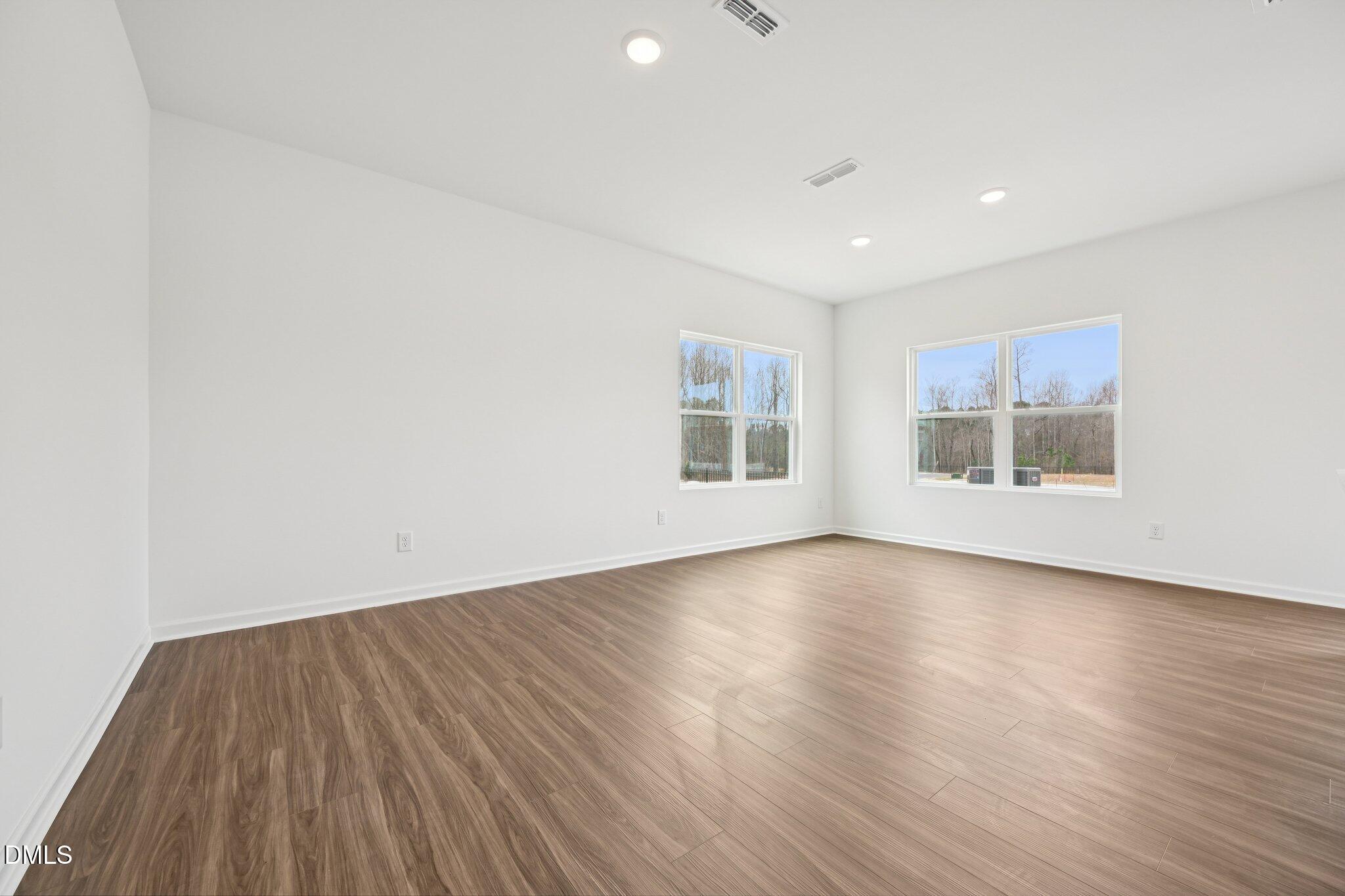 1610 Mirth Court Rolesville, NC 27571 - Photo 5 of 36 a view of an empty room with wooden floor and a window
