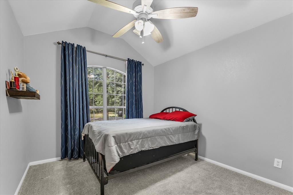 7 Market Loop Morgan's Point Resort, TX 76513 - Photo 19 of 31 Vaulted ceiling bedroom featuring a ceiling fan, carpet, and light grey walls