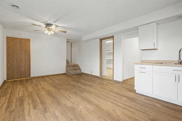a view of a kitchen with wooden floor and a ceiling fan