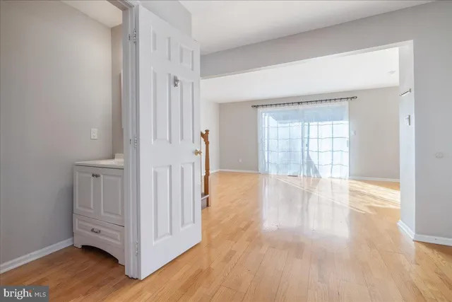 a view of an empty room with window and wooden floor