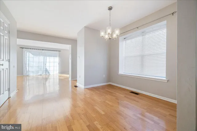 a view of a room with wooden floor and a ceiling fan