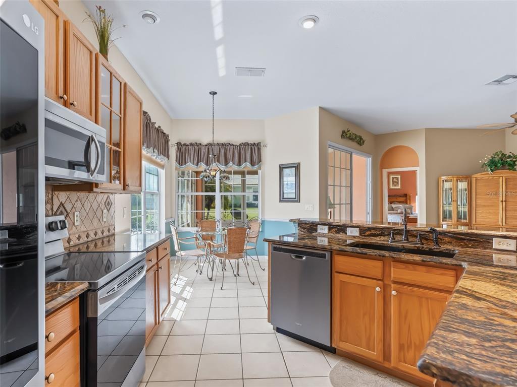 17786 Southeast 119th Avenue Road Summerfield, FL 34491 - Photo 11 of 43 a kitchen with stainless steel appliances granite countertop a sink and cabinets