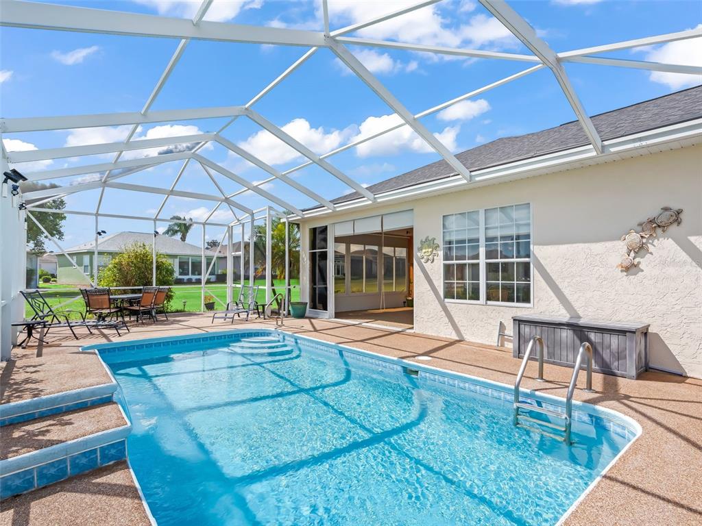 17786 Southeast 119th Avenue Road Summerfield, FL 34491 - Photo 14 of 43 a living room with furniture a flat screen tv and floor to ceiling window