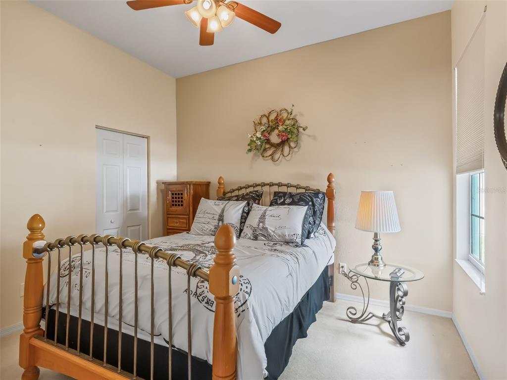 17786 Southeast 119th Avenue Road Summerfield, FL 34491 - Photo 26 of 43 a bedroom with a bed and a chandelier