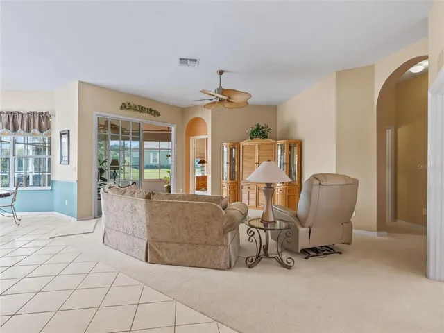a living room with furniture kitchen view and a chandelier