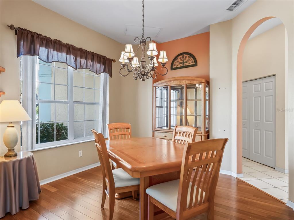 17786 Southeast 119th Avenue Road Summerfield, FL 34491 - Photo 9 of 43 a view of a dining room with furniture wooden floor and chandelier