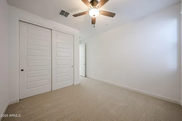 an empty room with closet and fan