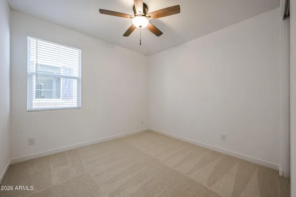 an empty room with a window and a fan