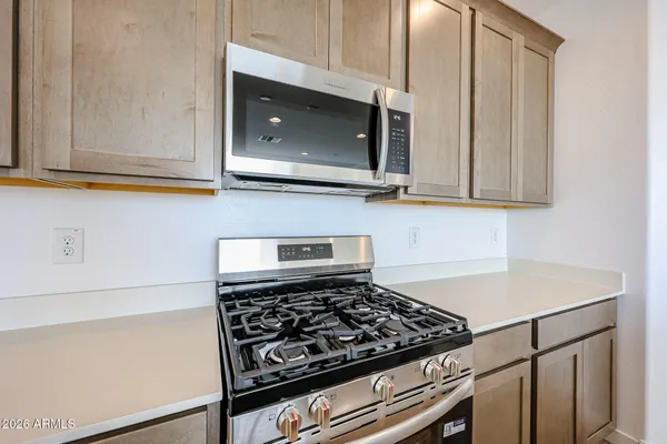 a kitchen with wooden cabinets and a stove top oven