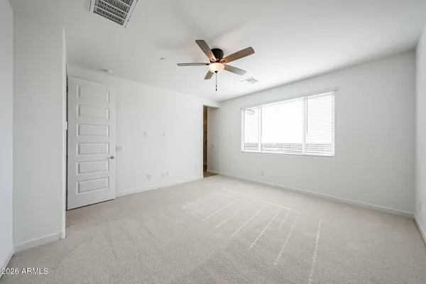 an empty room with windows and fan