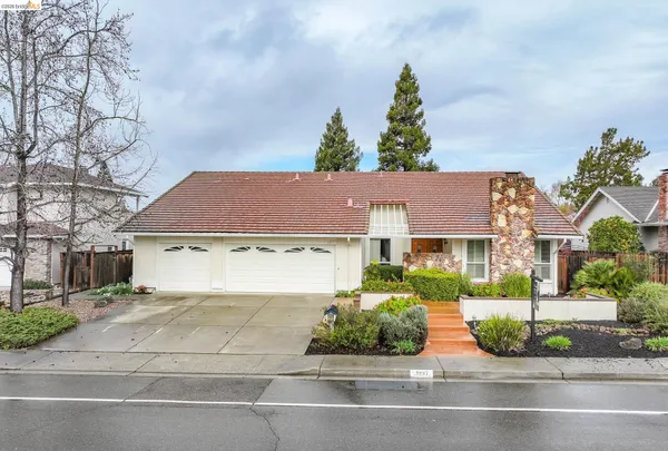 a front view of a house with a garden and plants