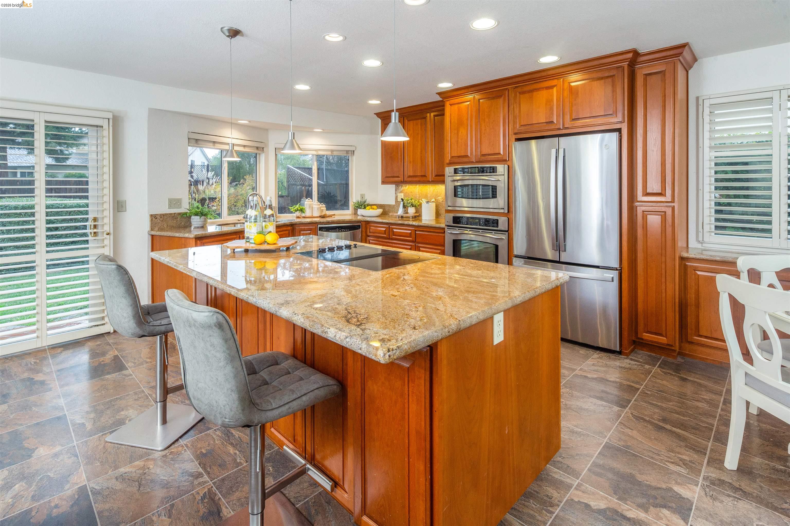 3237 Veracruz Drive San Ramon, CA 94583 - Photo 19 of 59 a dining hall with stainless steel appliances kitchen island granite countertop a table chairs and a refrigerator