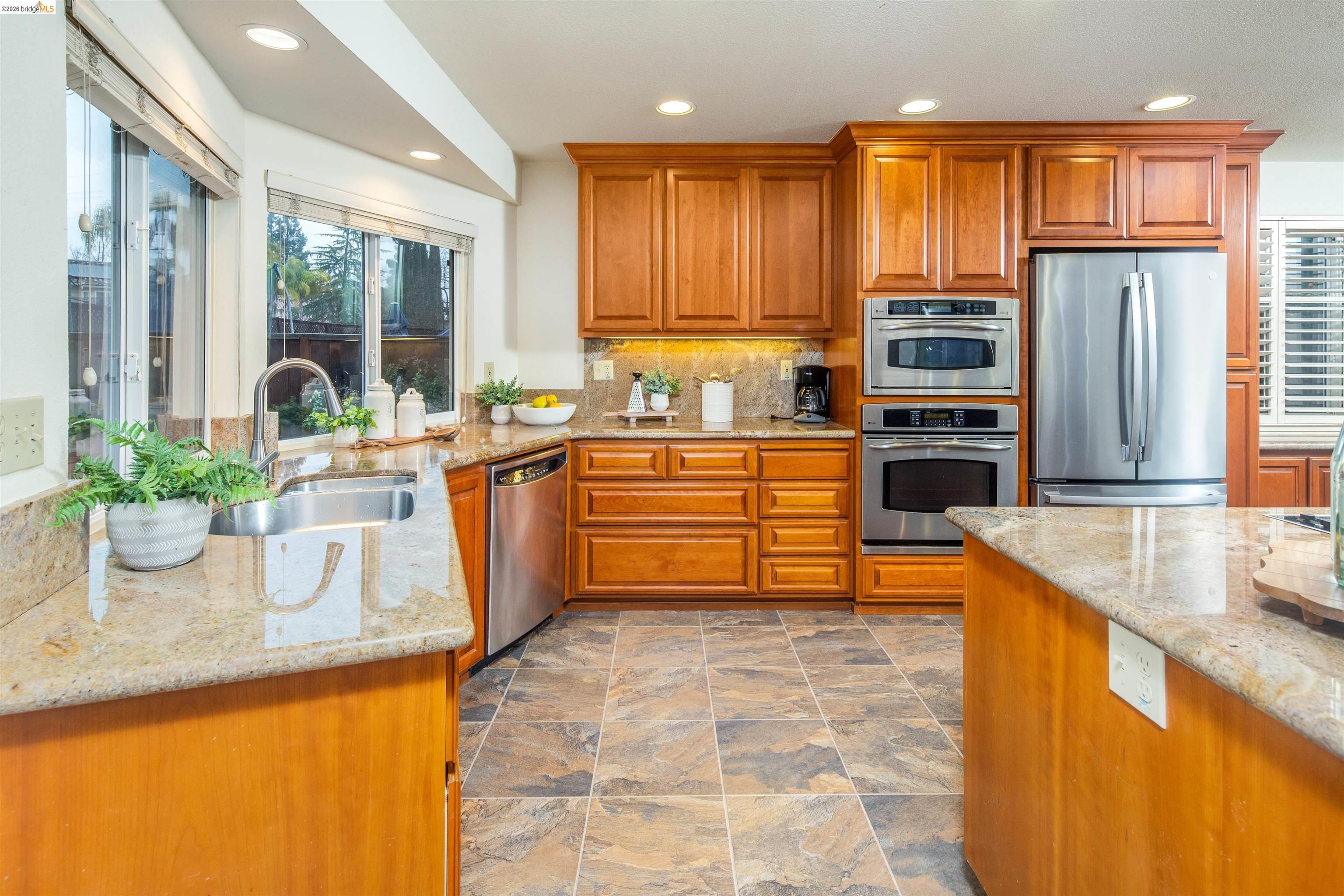 3237 Veracruz Drive San Ramon, CA 94583 - Photo 22 of 59 a kitchen with stainless steel appliances granite countertop a sink a stove and a wooden floors