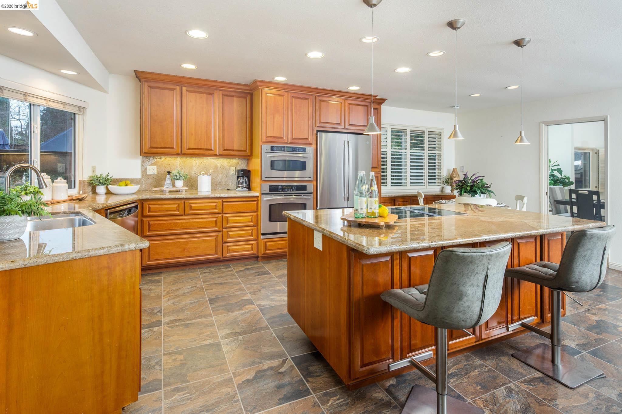 3237 Veracruz Drive San Ramon, CA 94583 - Photo 23 of 59 a kitchen with stainless steel appliances granite countertop table chairs sink refrigerator and cabinets