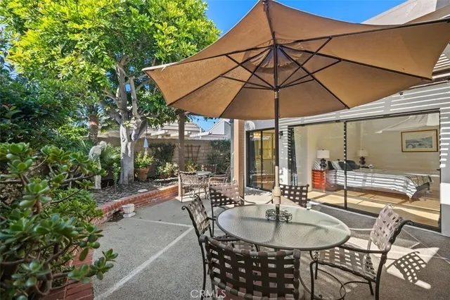 a patio with a table and chairs under an umbrella