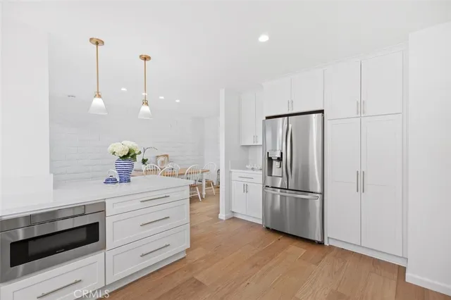 a kitchen with stainless steel appliances a refrigerator and a stove top oven