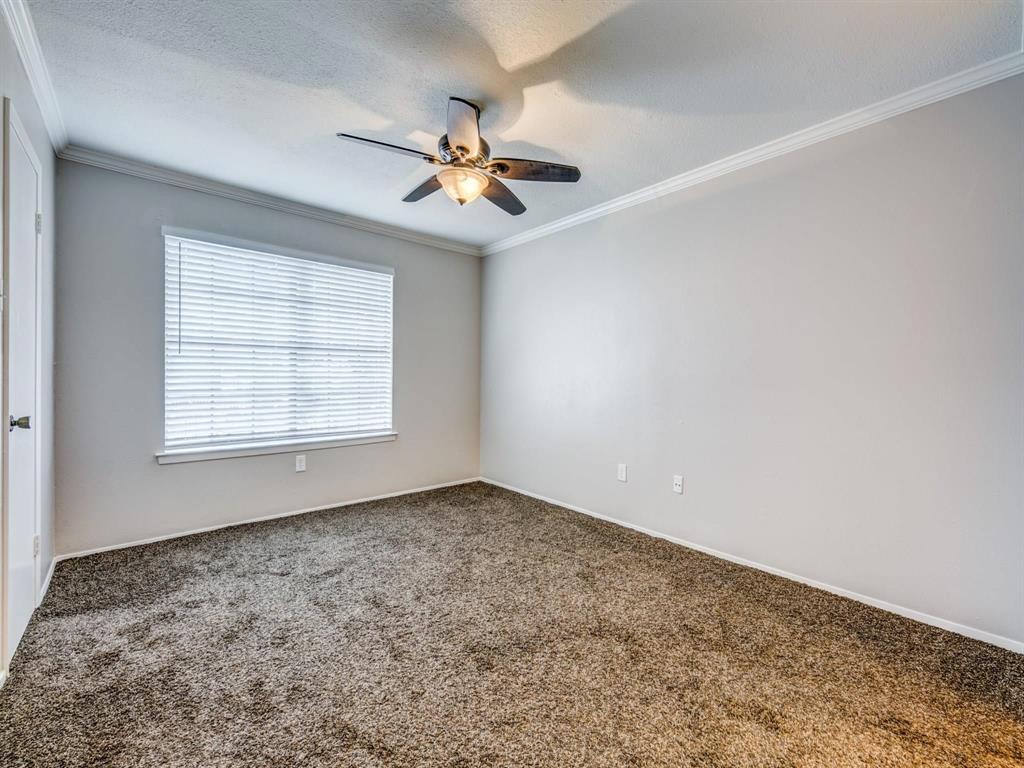 5626 Preston Oaks Road, Unit 39C Dallas, TX 75254 - Photo 6 of 38 Spare room with carpet floors, ornamental molding, a textured ceiling, and a ceiling fan
