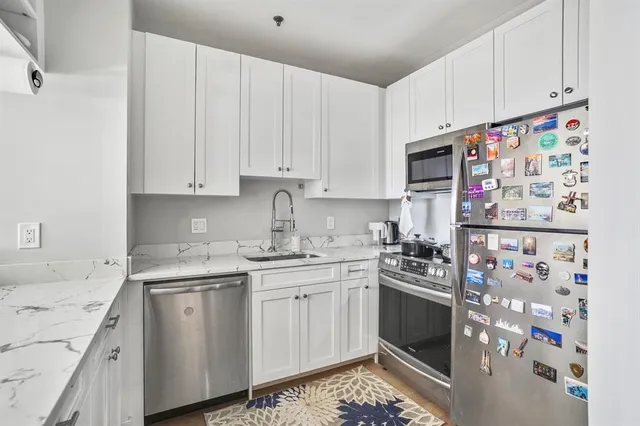 a kitchen with stainless steel appliances granite countertop a sink stove and cabinets