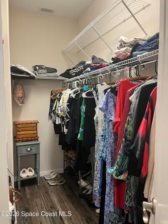 a view of walk in closet with clothes and shoes