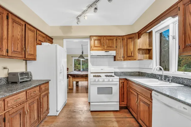 a kitchen with granite countertop a sink stove and refrigerator