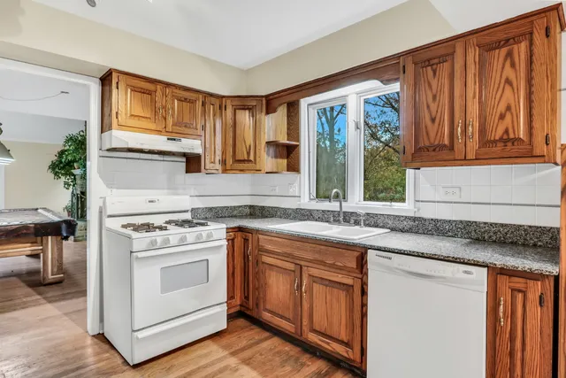 a kitchen with stainless steel appliances granite countertop a stove a sink and a microwave
