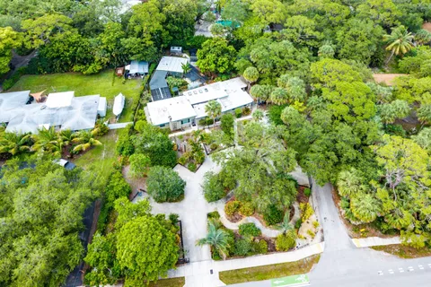 an aerial view of residential house with outdoor space and trees all around