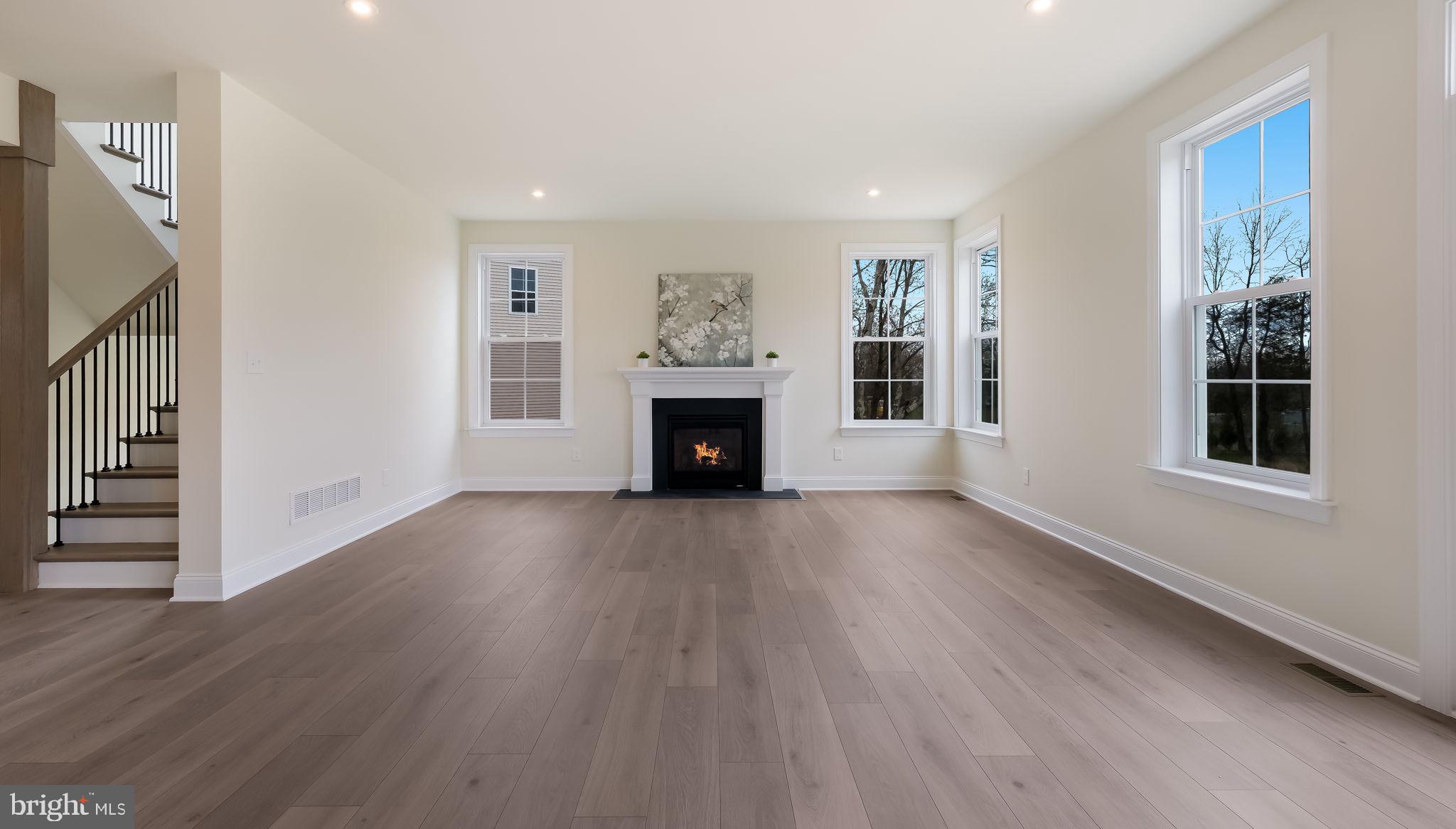1212 Jordan Lane Perkasie, PA 18944 - Photo 9 of 40 a view of an empty room with wooden floor fireplace and a window