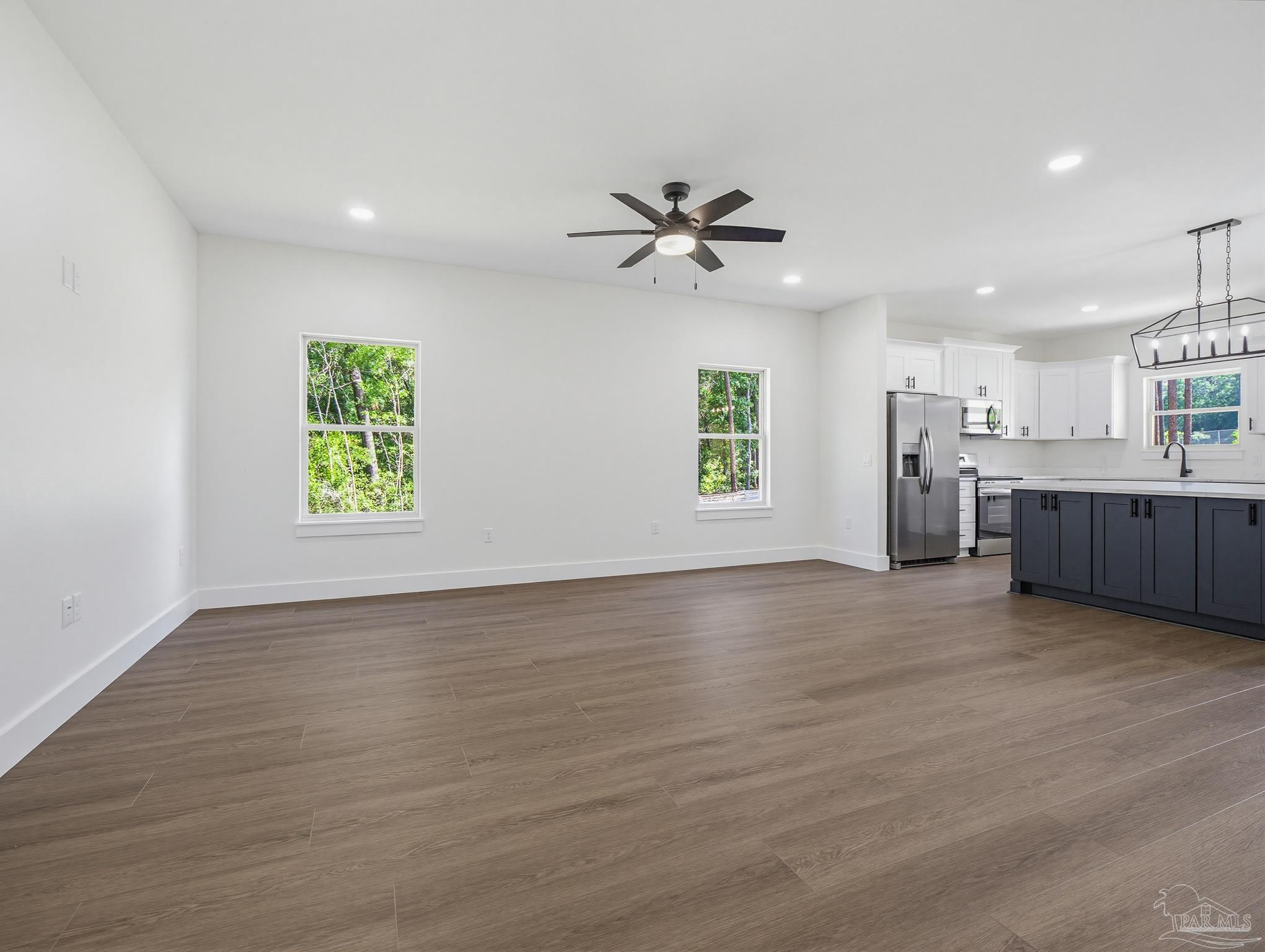 5724 Riviera Drive Milton, FL 32583 - Photo 9 of 52 a view of an empty room with a window and wooden floor