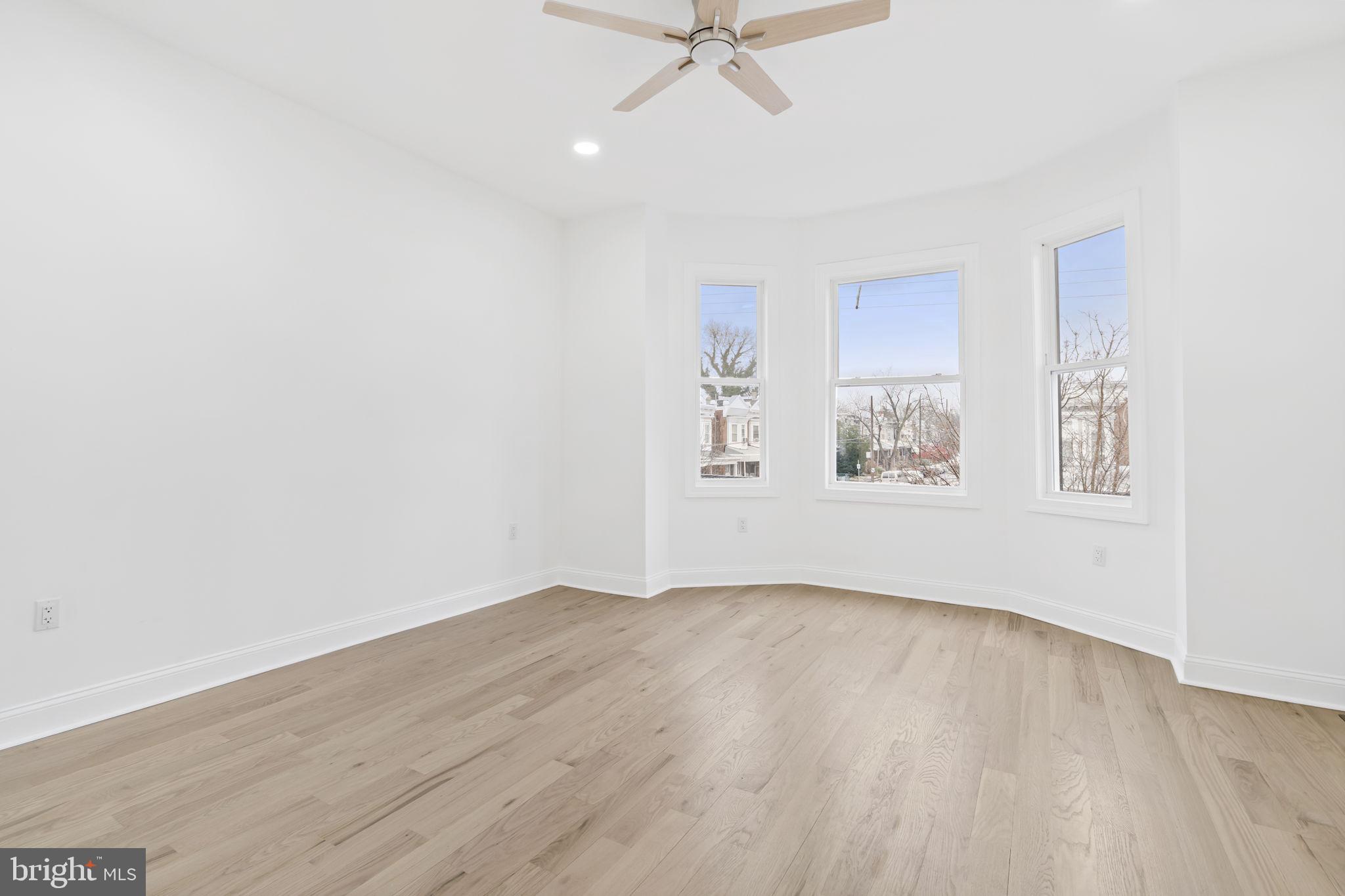 628 South 51st Street Philadelphia, PA 19143 - Photo 12 of 17 an empty room with wooden floor chandelier fan and windows