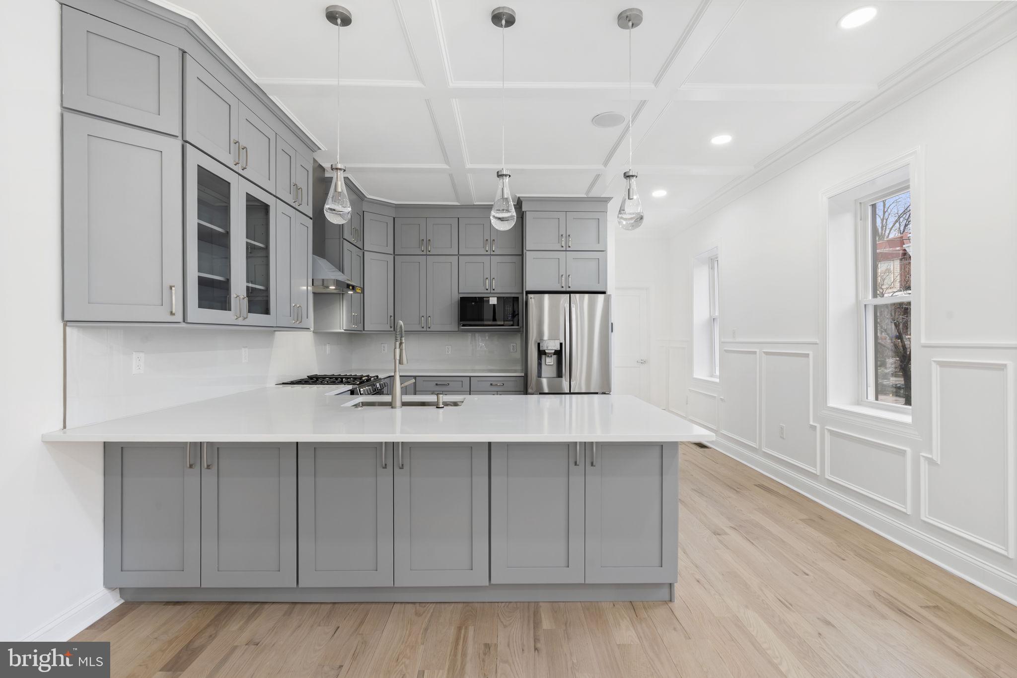 628 South 51st Street Philadelphia, PA 19143 - Photo 4 of 17 a kitchen with stainless steel appliances granite countertop a sink a stove and a wooden floors