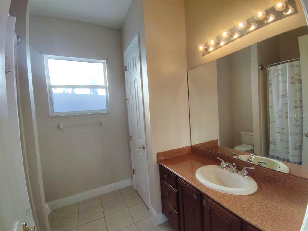 843 Glendora Road Poinciana, FL 34759 - Photo 11 of 15 a bathroom with a sink and a mirror