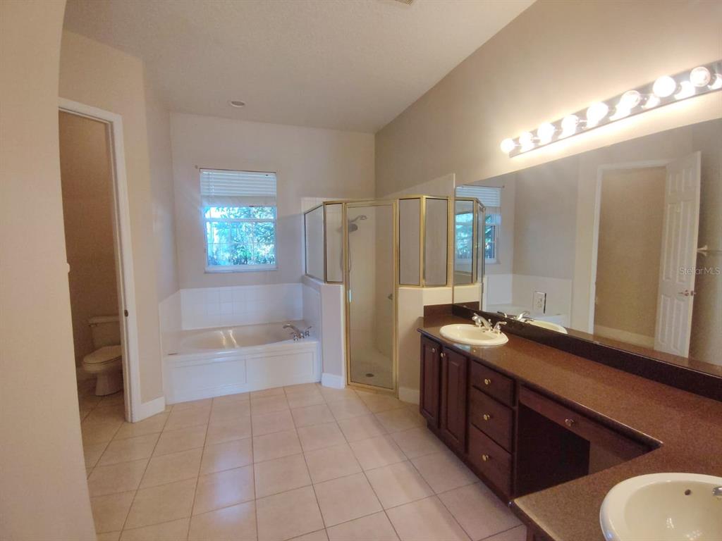 843 Glendora Road Poinciana, FL 34759 - Photo 13 of 15 a spacious bathroom with a tub sink and mirror