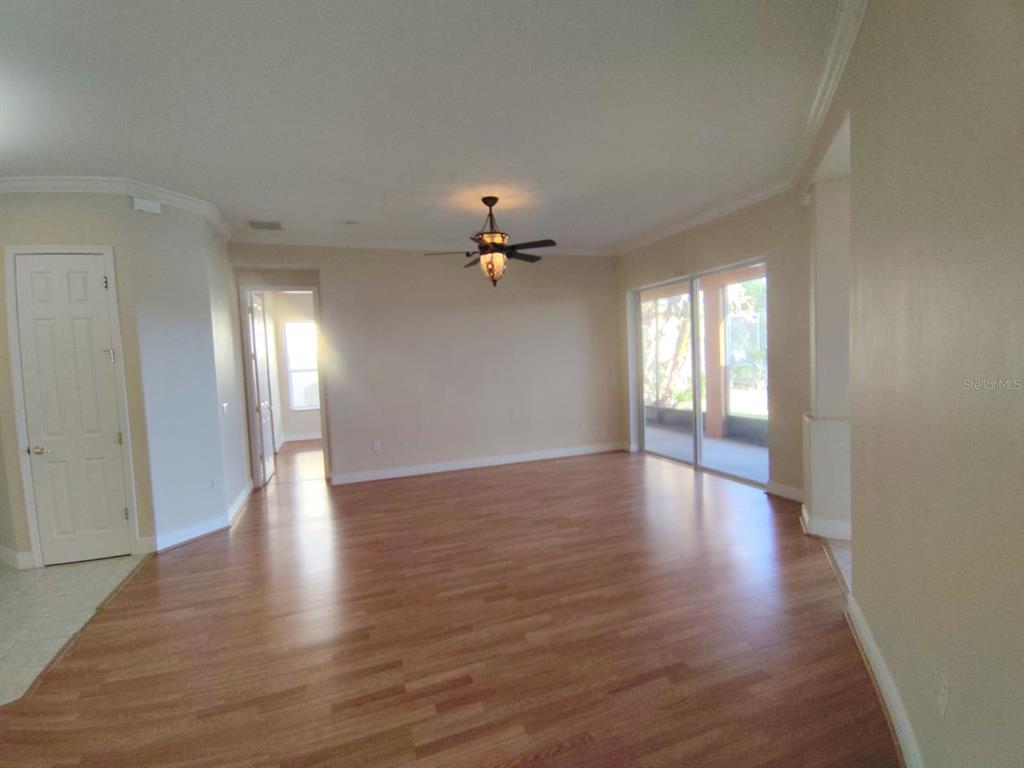 843 Glendora Road Poinciana, FL 34759 - Photo 5 of 15 a view of a livingroom with wooden floor and a ceiling fan