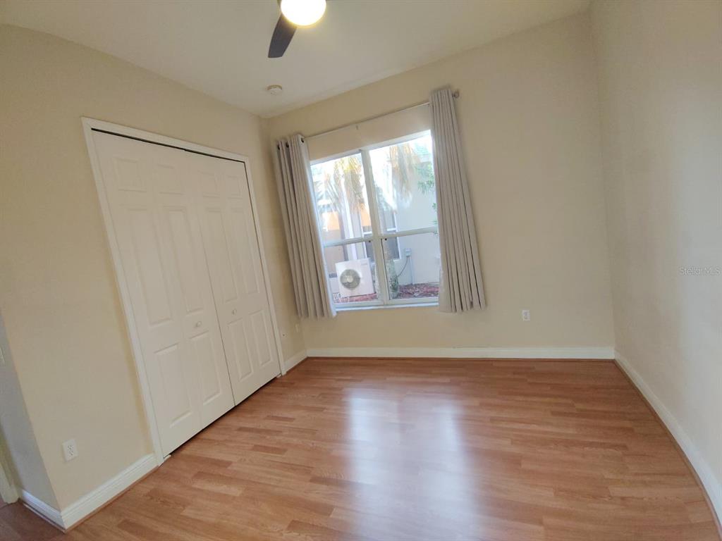 843 Glendora Road Poinciana, FL 34759 - Photo 6 of 15 an empty room with wooden floor and windows