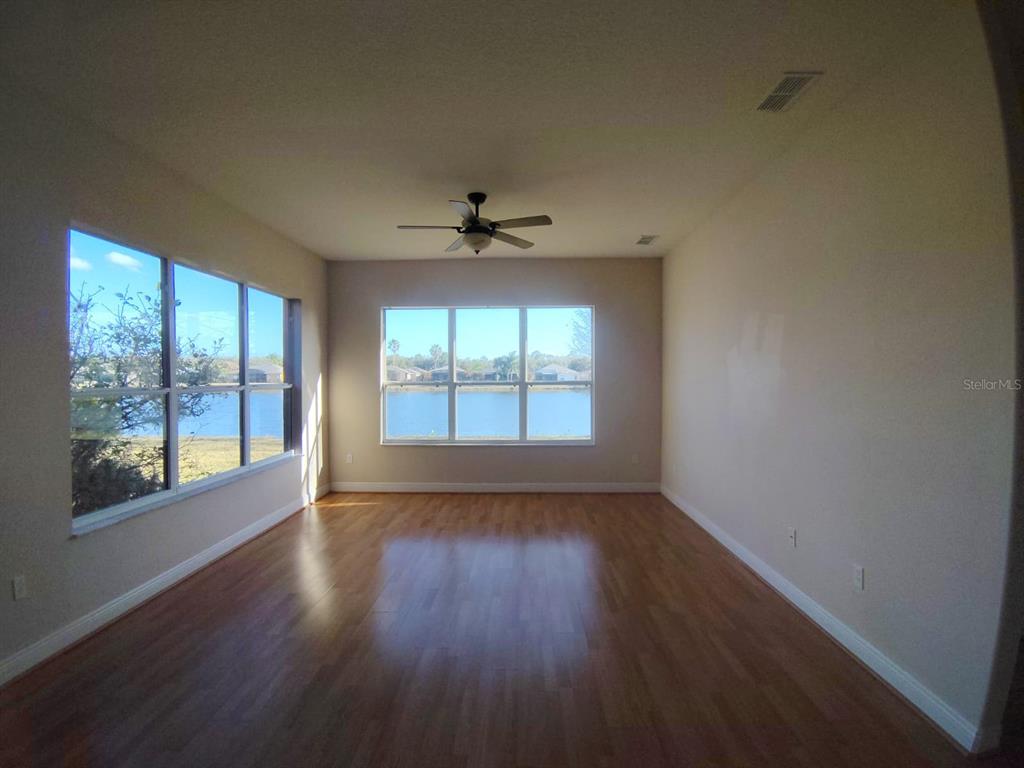 843 Glendora Road Poinciana, FL 34759 - Photo 8 of 15 an empty room with wooden floor and windows