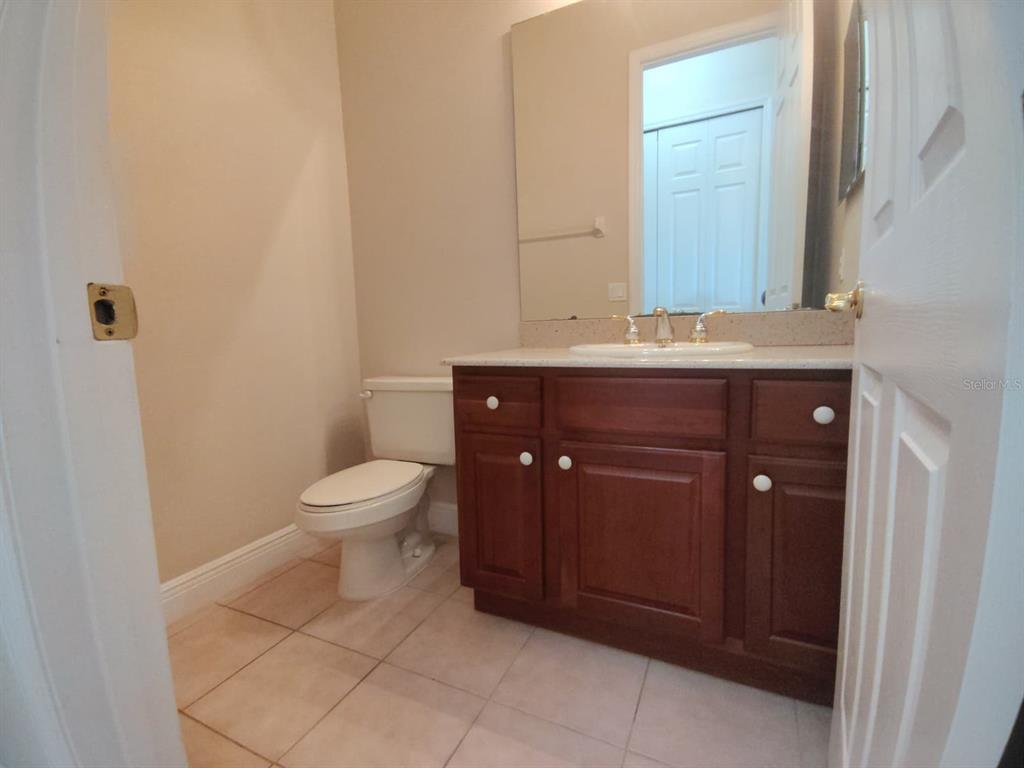 843 Glendora Road Poinciana, FL 34759 - Photo 10 of 15 a bathroom with a toilet a sink and mirror