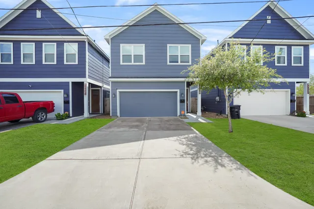 a front view of a house with a yard and a garage
